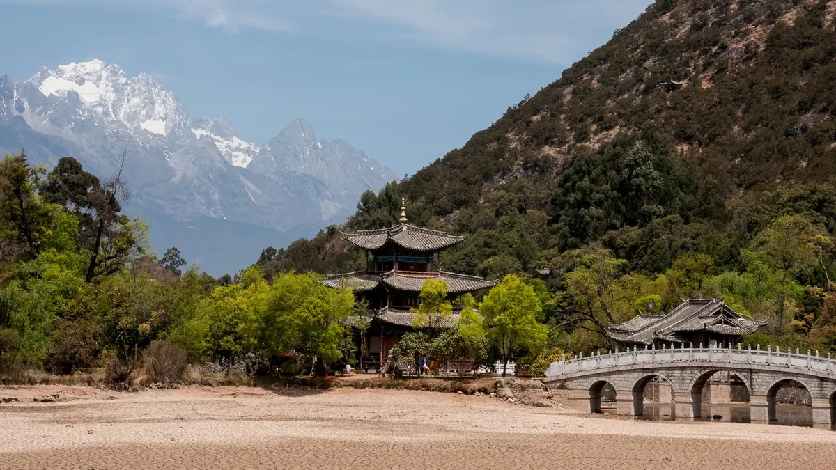 丽江黑龙潭晴天，玉龙雪山与蓝天下的古城亭桥，云南天气穿搭指南头图